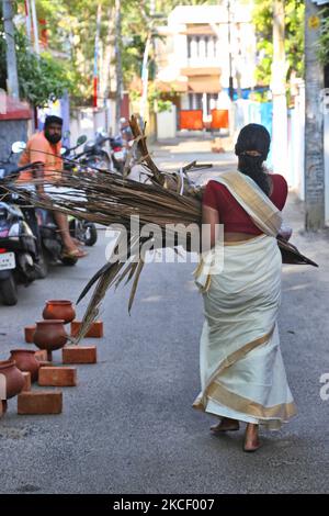 Die Hindu-Frau trägt ein Paket getrockneter Kokosblütenhüllen (Kothumbu), das als Brennstoff für ein Feuer beim Kochen von Pongala während des Attukal Pongala Mahotsavam Festivals in der Stadt Thiruvananthapuram (Trivandrum), Kerala, Indien, am 19. Februar 2019 verwendet wird. Das Attukal Pongala Mahotsavam Festival wird jedes Jahr von Millionen Hindu-Frauen gefeiert. Während dieses Festivals bereiten Frauen Pongala (Reis gekocht mit Jaggery, Ghee, Kokosnuss und anderen Zutaten) im Freien in kleinen Töpfen zu als ein Angebot an Göttin Attukal Devi (im Volksmund bekannt als Attukal Amma), die geglaubt wird, um die Wünsche ihrer de zu erfüllen Stockfoto