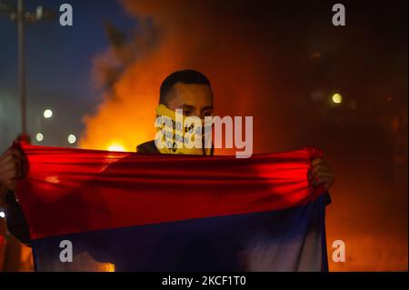 Ein Demonstrator hält eine kolumbianische Flagge mit einem Feuer auf dem Kopf, als Kolumbien seine 4.-wöchigen Anti-Regierung-Proteste gegen die Gesundheits- und Steuerreform von Präsident Ivan Duque beginnt, Fälle von Autoritätsmissbrauch durch die Polizei, bei denen mindestens 40 Tote und 18 Frauen seit Beginn der Proteste sexuell missbraucht wurden, sowie die Verwirklichung der Copa America in Kolumbien aufgrund der politischen und sozialen Situation am 19. Mai 2021 in Bogota, Kolumbien. (Foto von Sebastian Barros/NurPhoto) Stockfoto