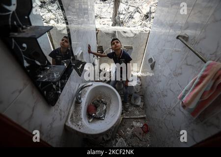Ein palästinensischer Junge inspiziert am 22. Mai 2021 in Gaza-Stadt die Trümmer von Gebäuden, die durch israelische Angriffe zerstört wurden. - Eine Waffenruhe im Konflikt zwischen Israel und palästinensischen Militanten im Gazastreifen, die von der islamistischen Gruppe Hamas kontrolliert wird, trat nach 11 Tagen Luftangriffe und Raketenbeschuss in Kraft. (Foto von Majdi Fathi/NurPhoto) Stockfoto