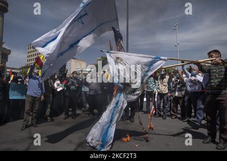 Iranische Demonstranten verbrennen am 22. Mai 2021 auf dem Palästinenserplatz im Zentrum von Teheran die US- und israelische Flagge bei einer Versammlung zur Unterstützung des palästinensischen Volkes. Eine Gruppe iranischer Männer und Frauen haben sich auf dem Palästinenserplatz versammelt, um den Sieg der Palästinenser über Israel zu feiern, so die Erklärung, die von einem Protestierenden gelesen wurde. (Foto von Morteza Nikoubazl/NurPhoto) Stockfoto