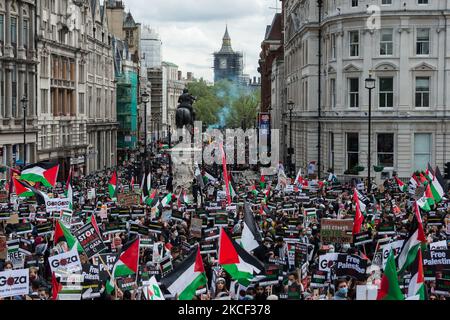 LONDON, VEREINIGTES KÖNIGREICH - 22. MAI 2021: Ein Protestler setzt ein Rauchflackern aus, als Zehntausende sich am 22. Mai 2021 auf dem Trafalgar Square im Zentrum von London versammeln, während eine Demonstration zur Unterstützung Palästinas in London, England, stattfindet. Am Freitag trat ein Waffenstillstand zwischen Israel und Palästina in Kraft, nachdem 11 Tage lang Luftangriffe durchgeführt wurden, bei denen mehr als 250 Menschen starben, als der Konflikt wegen geplanter Räumungen palästinensischer Familien aus ihren Häusern durch jüdische Siedler im Bezirk Sheikh Jarrah in Ostjerusalem und Auseinandersetzungen mit der Sicherheit eskalierte Truppen in der Altstadt während des Ramadan. (Foto von Wiktor Szymanow Stockfoto