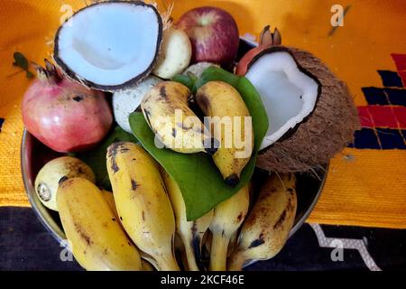 Ansicht von Gegenständen wie Früchten, Betelnussblättern und gebrochener Kokosnuss, die für Puja verwendet werden Stockfoto