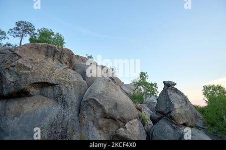 Riesige Felsformationen hoch in den Bergen mit wachsenden Bäumen an sonnigen Sommertagen Stockfoto