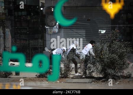 Palästinensische Freiwillige fegen am 25. Mai 2021 im Bezirk Rimal von Gaza-Stadt die Trümmer der Gebäude, die kürzlich durch israelische Angriffe zerstört wurden. (Foto von Majdi Fathi/NurPhoto) Stockfoto