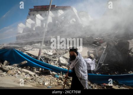 Palästinensische Freiwillige fegen am 25. Mai 2021 im Bezirk Rimal von Gaza-Stadt die Trümmer der Gebäude, die kürzlich durch israelische Angriffe zerstört wurden. (Foto von Majdi Fathi/NurPhoto) Stockfoto