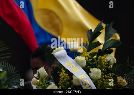 Eine kolumbianische Flagge wird hinter Beerdigungskränzen geschwenkt, während sich Menschen auf der Plaza de Bolivar vor dem Kongress-Kapitol versammeln, um den Misstrauensantrag an den kolumbianischen Verteidigungsminister Diego Molano zu unterstützen, nachdem mindestens 45 Todesfälle in Polizeibrutalitätsfällen während der anhaltenden Anti-Regierung-Proteste gegen Steuern und Gesundheit stattfanden In Kolumbien haben sich in den letzten Wochen Reformen und Polizeibrutalität entwickelt, am 24. Mai 2021 in Bogota, Kolumbien. (Foto von Sebastian Barros/NurPhoto) Stockfoto