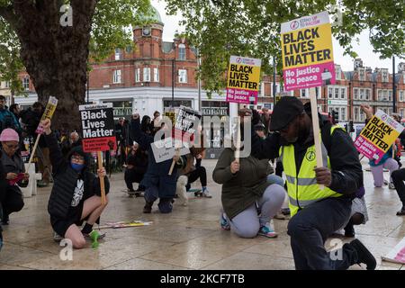 LONDON, VEREINIGTES KÖNIGREICH - 25. MAI 2021: Am Windrush Square in Brixton, im Süden Londons, knieen Menschen, um den ersten Jahrestag des Mordes an George Floyd durch einen Polizisten in Minneapolis zu begehen, Das löste am 25. Mai 2021 in London, England, eine globale Welle von Demonstrationen und das Wiederaufleben der Black Lives Matter-Bewegung aus. (Foto von Wiktor Szymanowicz/NurPhoto) Stockfoto