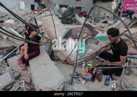 Palästinensische Künstler malen expressive Gemälde in den von Israel zerstörten Gebieten, die realistische menschliche Geschichten simulieren, die sich im jüngsten Krieg gegen Gaza ereignet haben. Am 26. Mai 2021 in Gaza City, Palästina. (Foto von Momen Faiz/NurPhoto) Stockfoto