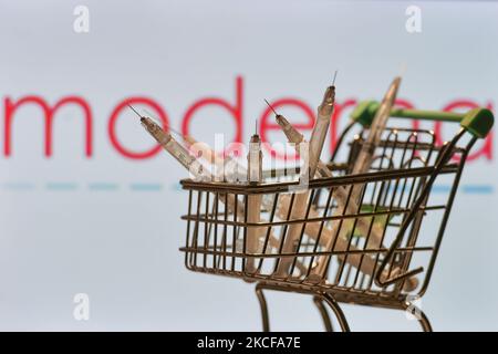 Medizinische Spritzen im Mini-Einkaufswagen sind vor dem Moderna-Logo auf einem Bildschirm zu sehen. Am Freitag, den 28. Mai 2021, in Dublin, Irland. (Foto von Artur Widak/NurPhoto) Stockfoto