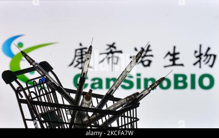 Medizinische Spritzen im Mini-Einkaufswagen sind vor dem CanSino Bio-Logo auf einem Bildschirm zu sehen. Am Freitag, den 28. Mai 2021, in Dublin, Irland. (Foto von Artur Widak/NurPhoto) Stockfoto