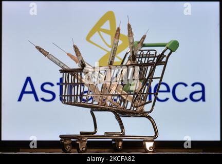 Medizinische Spritzen im Mini-Einkaufswagen sind vor dem AstraZeneca-Logo auf einem Bildschirm zu sehen. Am Freitag, den 28. Mai 2021, in Dublin, Irland. (Foto von Artur Widak/NurPhoto) Stockfoto