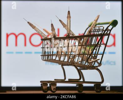 Medizinische Spritzen im Mini-Einkaufswagen sind vor dem Moderna-Logo auf einem Bildschirm zu sehen. Am Freitag, den 28. Mai 2021, in Dublin, Irland. (Foto von Artur Widak/NurPhoto) Stockfoto