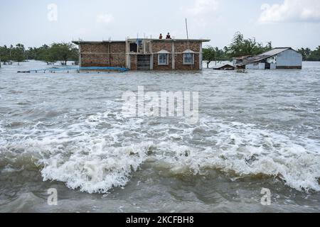 Eine Familie hat sich auf dem Dach unterbringen lassen, als die Flusswälle zerbrochen sind und mehrere Dörfer überschwemmt wurden. Am 28. Mai 2021 in South 24 Parganas, Westbengalen, Indien. Die Menschen in Westbengalen sind stark betroffen, da Flussdämme gebrochen sind und mehrere Dörfer aufgrund von Hochwasser und starkem Regen aufgrund des Super-Wirbelsturms YaaS überflutet wurden. (Foto von Dipayan Bose/NurPhoto) Stockfoto