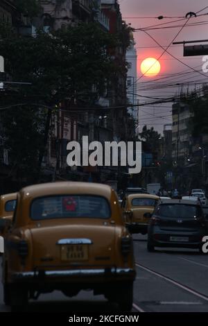 Verschwender Blick auf die Natur, während die Sonne am Himmel untergeht, und das Taxi des Gelben Botschafters überquert die Straße während einer Sperre, die vom westbengalischen Staat auferlegt wurde, um die Ausbreitung des Covid-19-Coronavirus am 02,2021. Juni in Kalkutta einzudämmen. Indien meldete heute 132.788 frische Covid-19-Infektionen, so dass die Kaseloade auf 28.307.832 angesetzt wurde. Mit 3.207 neuen Todesopfern liegt die Zahl der Todesopfer laut MoHFW jetzt bei 335.102. Indien ist nach wie vor die zweitschlechteste Nation. Die Testpositivitätsrate ist auf 6,57 Prozent gesunken. Mit 26.513 gemeldeten Fällen in den letzten 24 Stunden führt Tamil Nadu die Liste der Bundesstaaten an. Es folgt Kar Stockfoto