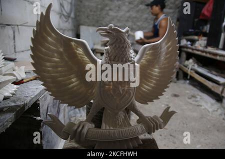 Handwerker machen am 2. JUNI eine Statue von Garuda Pancasila als Symbol des Staates in einer Heimindustrie im Großraum Bali, Kalimalang, Ost-Jakarta, 2021. Dieses Geschäft hat während der Covid-19-Pandemie wieder aufleben lassen, als Befehle von verschiedenen nationalen Symbolen aus einer Reihe von Regionen innerhalb und außerhalb Indonesiens kamen, um als Büro- und Schulwanddekoration verwendet zu werden. (Foto von Dasril Roszandi/NurPhoto) Stockfoto