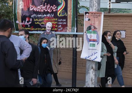 Iranische Frauen kommen an einem Wahlplakat und einem Bildnis des ehemaligen iranischen Korps der Islamischen Revolutionsgarde (IRGC) Quds Force General Qasem Soleimani vorbei, der während der Tage der Präsidentschaftswahlen am 4. Juni 2021 bei einem amerikanischen Drohnenangriff auf dem Flughafen Bagdad im Süden Teherans getötet wurde. (Foto von Morteza Nikoubazl/NurPhoto) Stockfoto