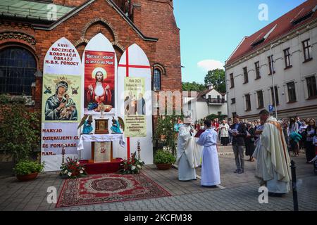 Katholiken feiern Fronleichnam, die an der Heiligen Messe und Prozession während der Coronavirus-Pandemie teilnehmen. Krakau, Polen, am 4. Juni 2021. Die Prozession beginnt mit einem Priester, der eine Monstranz unter einem Baldachin trägt. Die Gläubigen folgen ihm und singen religiöse Hymnen, während junge Mädchen in weißen oder traditionellen regionalen Kleidern Blütenblätter entlang der Route verteilen. Fronleichnam ist ein katholisches bewegliches Fest zum Gedenken an die Substitution. (Foto von Beata Zawrzel/NurPhoto) Stockfoto