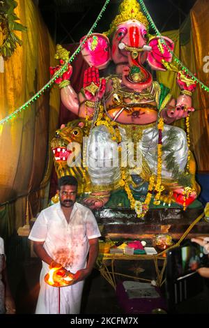 Tamilischer Hindu-Priester führt Gebete durch ein großes Lehm-Idol von Lord Ganesha (Lord Ganesh) an einem Pandal (temporärer Schrein) entlang der Straße während des Festivals von Ganesh Chaturtschi in Kuttalam, Tamil Nadu, Indien, durch. Ganesh Chaturtti (auch bekannt als Vinayaka Chaturtti) ist ein hinduistisches Fest, das die Ankunft von Ganesh von Kailash Parvat mit seiner Mutter Göttin Parvati auf die Erde feiert. (Foto von Creative Touch Imaging Ltd./NurPhoto) Stockfoto