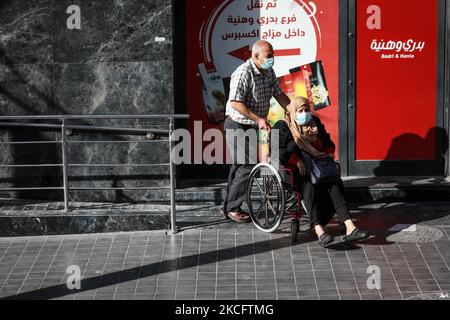 Am 08. Juni 2021 schauen Palästinenser mit Schutzmasken auf ägyptische Arbeiter und Maschinen, die die Trümmer der zerstörten Türme und Häuser in Gaza-Stadt entfernen. Ägypten gab am 04. Juni bekannt, dass es Arbeiter und Ausrüstung entsendet, um nach den Kämpfen zwischen Israel und Aktivisten im Gazastreifen beim Wiederaufbau zu helfen. (Foto von Majdi Fathi/NurPhoto) Stockfoto