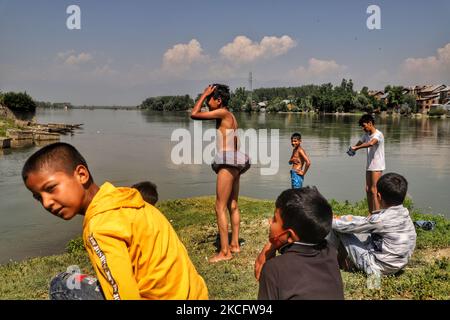 Kashmiri-Jungen kühlen sich am 09. Juni 2021 im Fluss Jehlum ab, um an einem heißen Sommertag in der Stadt Sopore im Distrikt Baramulla, etwa 60Kms von Srinagar in Jammu und Kaschmir, Indien, die Hitze zu besiegen. Während die anhaltende erste Hitzewelle des Jahres in Kaschmir in den nächsten zwei weiteren Tagen anhalten wird, wird davon ausgegangen, dass der Monsun die Region treffen und ab Juni 11 leichte Regenfälle mit sich bringen wird. Fast zwei Jahre seit der Aufhebung von Artikel 370 erlebt der Staat Jammu & Kaschmir in diesen Tagen eine hektische politische Aktivität. Quellen sagen, dass die Abgrenzungskommission wahrscheinlich den nördlichen Staat so besuchen wird Stockfoto