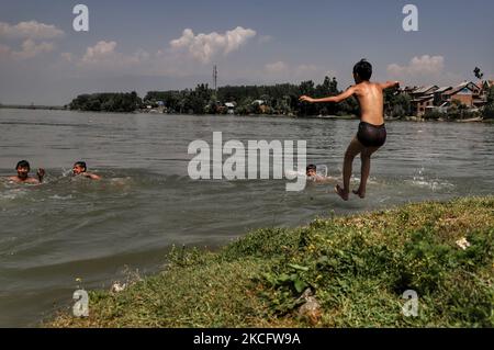 Kashmiri-Jungen kühlen sich am 09. Juni 2021 im Fluss Jehlum ab, um an einem heißen Sommertag in der Stadt Sopore im Distrikt Baramulla, etwa 60Kms von Srinagar in Jammu und Kaschmir, Indien, die Hitze zu besiegen. Während die anhaltende erste Hitzewelle des Jahres in Kaschmir in den nächsten zwei weiteren Tagen anhalten wird, wird davon ausgegangen, dass der Monsun die Region treffen und ab Juni 11 leichte Regenfälle mit sich bringen wird. Fast zwei Jahre seit der Aufhebung von Artikel 370 erlebt der Staat Jammu & Kaschmir in diesen Tagen eine hektische politische Aktivität. Quellen sagen, dass die Abgrenzungskommission wahrscheinlich den nördlichen Staat so besuchen wird Stockfoto