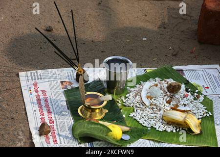 Lampe und Opfergaben, die als Hindu-Frauen gesehen werden, beenden die letzten Vorbereitungen, bevor sie am Morgen des letzten Tages des 10-tägigen Attukal Pongala Mahotsavam Festivals in der Stadt Thiruvananthapuram (Trivandrum), Kerala, Indien, am 19. Februar 2019 Pongala am Straßenrand kochen. Das Attukal Pongala Mahotsavam Festival wird jedes Jahr von Millionen Hindu-Frauen gefeiert. Während dieses Festivals bereiten Frauen Pongala (Reis gekocht mit Jaggery, Ghee, Kokosnuss sowie anderen Zutaten) im Freien in kleinen Töpfen zu, um der Göttin Kannaki zu gefallen. Pongala (was wörtlich bedeutet, überkochen) ist ein Rituali Stockfoto