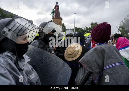 Misak-Indigene stehen vor Polizeibeamten, als sie am 09. Juni 2021 in Bogota, Kolumbien, neben der Statue der spanischen Königin Isabel protestiert. Ein weiterer Tag der Proteste in Bogota, Kolumbien, heute in Begleitung der indigenen Misak, die vorgaben, die Statue von "Isabel der katholikin" und Cristobal Colon Eroberer von Amerika niederzubringen. (Foto von David Rodriguez/NurPhoto) Stockfoto