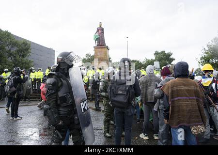 Misak-Indigene stehen vor Polizeibeamten, als sie am 09. Juni 2021 in Bogota, Kolumbien, neben der Statue der spanischen Königin Isabel protestiert. Ein weiterer Tag der Proteste in Bogota, Kolumbien, heute in Begleitung der indigenen Misak, die vorgaben, die Statue von "Isabel der katholikin" und Cristobal Colon Eroberer von Amerika niederzubringen. (Foto von David Rodriguez/NurPhoto) Stockfoto