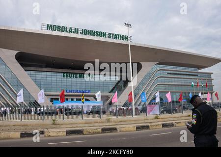 Am 10. Juni 2021 steht ein Polizeimann vor der Frontansicht des neu in Betrieb genommenen Bahnhofs Mobolaji Johnson in Ebutemeta, Lagos, Nigeria. Präsident Muhammadu Buhari besuchte am Donnerstag Lagos zur Einweihung des 157 Kilometer langen Standardbahnprojekts Lagos-Ibadan am Bahnhof Mobolaji Johnson in Ebute Metta. Die Bauarbeiten begannen im März 2017 und die Testarbeiten begannen im Dezember 2020. Der Bahnhof Ebute Metta, der als Mobolaji Johnson Station bekannt ist, ist der größte Bahnhof in Westafrika mit einer Haltekapazität von 6000 Passagieren Stockfoto