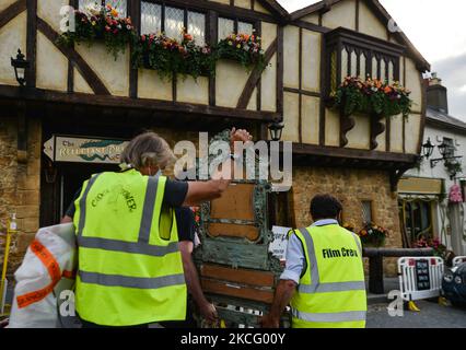 Die Filmcrew-Mitglieder tragen einen alten Sessel im Zentrum des Dorfes Enniskerry in der Grafschaft Wicklow. Es sind nur noch zwei Tage, bis die Dreharbeiten für Disneys „enttäuschte“ Hauptrolle mit Amy Adams, Patrick Dempsey, James Marsden, Idina Menzel und Maya Rudolph beginnen. Ein Team von Zimmerleuten, Malern, Baumeistern und Dekorateuren hat den letzten Schliff gegeben, um Teile des Dorfes wie ein magisches Disney-Wunderland aussehen zu lassen. Am Freitag, den 11. Juni 2021, in Enniskerry, County Wicklow, Irland. (Foto von Artur Widak/NurPhoto) Stockfoto