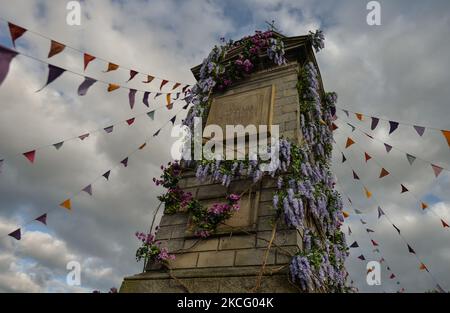 Der mit Blumen geschmückte Uhrenturm im Dorf Enniskerry in der Grafschaft Wicklow. Es sind nur noch zwei Tage, bis die Dreharbeiten für Disneys „enttäuschte“ Hauptrolle mit Amy Adams, Patrick Dempsey, James Marsden, Idina Menzel und Maya Rudolph beginnen. Ein Team von Zimmerleuten, Malern, Baumeistern und Dekorateuren hat den letzten Schliff gegeben, um Teile des Dorfes wie ein magisches Disney-Wunderland aussehen zu lassen. Am Freitag, den 11. Juni 2021, in Enniskerry, County Wicklow, Irland. (Foto von Artur Widak/NurPhoto) Stockfoto