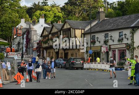 Besucher, die im Dorf Enniskerry in der Grafschaft Wicklow die Hauptstraße mit den mit Blumen geschmückten, transformierten Häusern umfahren. Es sind nur noch zwei Tage, bis die Dreharbeiten für Disneys „enttäuschte“ Hauptrolle mit Amy Adams, Patrick Dempsey, James Marsden, Idina Menzel und Maya Rudolph beginnen. Ein Team von Zimmerleuten, Malern, Baumeistern und Dekorateuren hat den letzten Schliff gegeben, um Teile des Dorfes wie ein magisches Disney-Wunderland aussehen zu lassen. Am Freitag, den 11. Juni 2021, in Enniskerry, County Wicklow, Irland. (Foto von Artur Widak/NurPhoto) Stockfoto