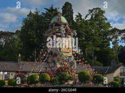 Der mit Blumen geschmückte Uhrenturm im Dorf Enniskerry in der Grafschaft Wicklow. Es sind nur noch zwei Tage, bis die Dreharbeiten für Disneys „enttäuschte“ Hauptrolle mit Amy Adams, Patrick Dempsey, James Marsden, Idina Menzel und Maya Rudolph beginnen. Ein Team von Zimmerleuten, Malern, Baumeistern und Dekorateuren hat den letzten Schliff gegeben, um Teile des Dorfes wie ein magisches Disney-Wunderland aussehen zu lassen. Am Freitag, den 11. Juni 2021, in Enniskerry, County Wicklow, Irland. (Foto von Artur Widak/NurPhoto) Stockfoto