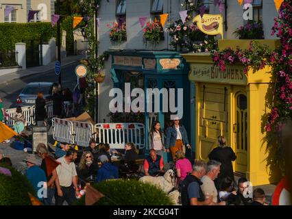 Transformierte Fassaden lokaler Geschäfte und blumengeschmückte Häuser im Zentrum von Enniskerry in der Grafschaft Wicklow. Es sind nur noch zwei Tage, bis die Dreharbeiten für Disneys „enttäuschte“ Hauptrolle mit Amy Adams, Patrick Dempsey, James Marsden, Idina Menzel und Maya Rudolph beginnen. Ein Team von Zimmerleuten, Malern, Baumeistern und Dekorateuren hat den letzten Schliff gegeben, um Teile des Dorfes wie ein magisches Disney-Wunderland aussehen zu lassen. Am Freitag, den 11. Juni 2021, in Enniskerry, County Wicklow, Irland. (Foto von Artur Widak/NurPhoto) Stockfoto