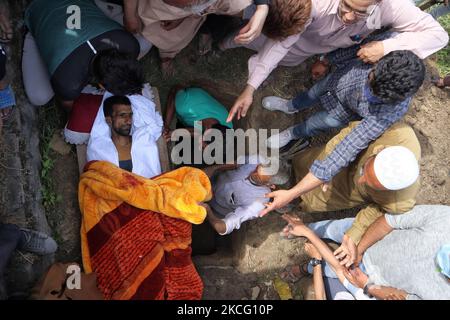 (HINWEIS DER REDAKTION: Das Bild enthält grafische Inhalte.) Menschen begraben den getöteten Zivilisten Bashir Ahmad, der am 12. Juni 2021 bei einer Schießerei im Bezirk Sovore, nördlich von Srinagar, im indischen Kaschmir, getötet wurde. Zwei Zivilisten und zwei Polizisten wurden bei einer Schießerei zwischen indischen Streitkräften und mutmaßlichen Rebellen getötet, doch die Einheimischen beschuldigen die Streitkräfte, die Zivilbevölkerung zu targeting. (Foto von Muzamil Mattoo/NurPhoto) Stockfoto