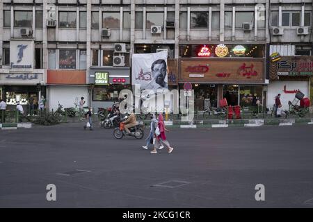 Zwei iranische Frauen mit Schutzmaske laufen während der Tage der Präsidentschaftswahlen im Iran am 12. Juni 2021 am Wahlbanner eines Präsidentschaftskandidaten Mohsen Rezaee im Norden Teherans vorbei. (Foto von Morteza Nikoubazl/NurPhoto) Stockfoto