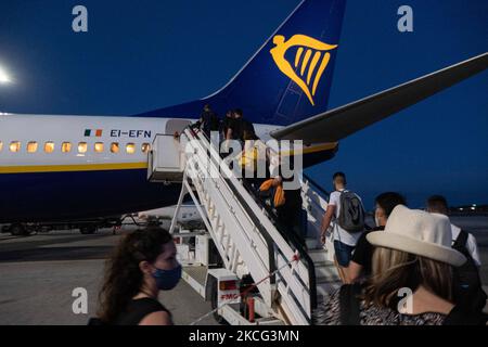 Passagiere werden nach Sonnenuntergang in einer Boeing 737-800 mit der Registrierung Ei-EFN von Ryanair, der irischen Low Cost Airline Carrier, am Chania Airport CHQ auf der griechischen Insel Kreta an Bord gehen sehen. Reisende müssen einen Nachweis über die Impfung oder den Covid-19 Coronavirus-Negativtest erhalten und eine obligatorische Gesichtsmaske tragen, eine Maßnahme wegen der Pandemie. Kreta ist ein beliebtes Urlaubsziel. Chania, Griechenland am 13. Juni 2021 (Foto von Nicolas Economou/NurPhoto) Stockfoto