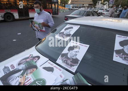 Ein Anhänger des Präsidentschaftswahlkandidaten Ebrahim Raisi, der am 15. Juni 2021 während eines Wahlkampfs in der Innenstadt von Teheran ein Wahlplakat von Raisi trug. (Foto von Morteza Nikoubazl/NurPhoto) Stockfoto