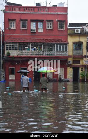 Am 17. Juni 2021 wateten Männer durch eine Wasserstrasse in Kalkutta, Indien. Starke Niederschläge behinderten das tägliche Leben der Hauptstadt Kalkutta. Viele Orte in Kalkutta ist vollständig Wasser aufgrund von starken regen, die in der späten Nacht des 16.. Juni begann protokolliert. (Foto von Sukhomoy Sen/NurPhoto) Stockfoto