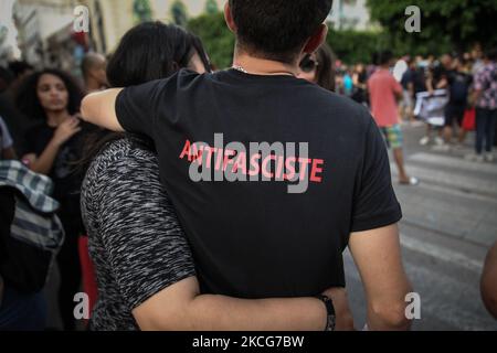 Ein junger Mann mit einem T-Shirt, das auf Französisch ‘antifaschistisch’ steht, umarmt ein Mädchen, während sie an einer Demonstration teilnehmen, die am 18. Juni 2021 in der Avenue Habib Bourguiba in Tunis, Tunesien, stattfand, um gegen Polizeirepression und Straflosigkeit zu protestieren. (Foto von Chedly Ben Ibrahim/NurPhoto) Stockfoto