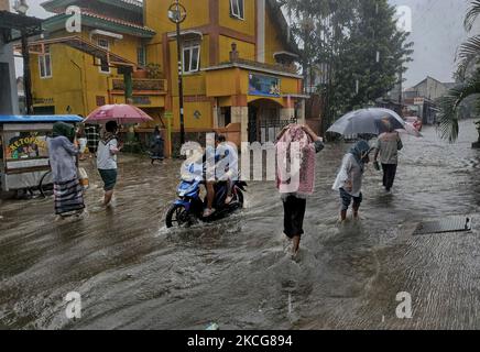 Pendler machen sich am 18. Juni 2021 nach heftigen Regenfällen in Bogor Regency, West Java, Indonesien, auf einer wasserdurchfluten Straße auf den Weg. (Foto von Adriana Adie/NurPhoto) Stockfoto