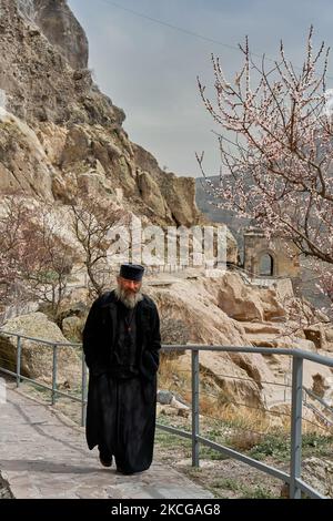 Der Ruzin-Priester in einer Soutane spaziert durch die Höhlenstadt im Felsen. Tiflis, Georgien - 04.09.2021 Stockfoto