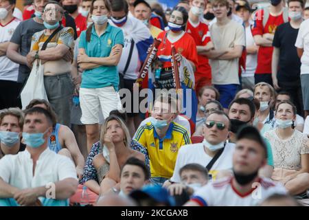 Der ukrainische Unterstützer (C) beobachtet einen Live-Stream zusammen mit russischen Anhängern während des UEFA Euro 2020-Meisterschaftsspiel zwischen Austra und der Ukraine am 21. Juni 2021 in der Fan Zone auf dem Konyushennaya-Platz in Sankt Petersburg, Russland. (Foto von Mike Kireev/NurPhoto) Stockfoto