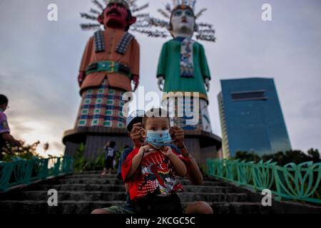 Kinder tragen Gesichtsmasken in der Nähe der Ondel-ondel-Statue in Jakarta am 22. Juni 2021. Anies Baswedan, Gouverneurin von Jakarta, sagte, dass es ein neues Muster in der jüngsten Zunahme der Covid-19-Fälle in der Hauptstadt gebe. Ihm zufolge nimmt die Zahl der Covid-19-Patienten unter den Kindern zu. Es ist höchstwahrscheinlich auf eine neue Variante zurückzuführen, die ansteckender ist, auch für Kinder. Er zitierte ein Beispiel, dass die Stadt am Sonntag, dem 20. Juni, 5.582 neue Fälle meldete und dass 16 Prozent von ihnen Kinder waren. (Foto von Afriadi Hikmal/NurPhoto) Stockfoto