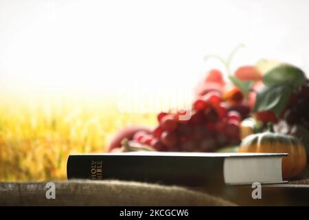 Kirche Thanksgiving Day Obst Dekoration mit bibel und geerntetem Getreide und Getreide Hintergrund Stockfoto