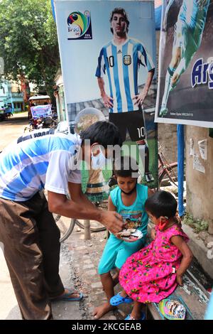 Shib Shankar Patra ( L ), Fußballfan von Argentinien Team, Dristribute Kuchen während 34. Geburtstagsfeier des weltberühmten Fußballprofis Lionel Messi bei North 24 Pargana Kolkata bis 27 Kilometer Entfernungen nördlich, West Bengalen, Indien, am 24. Juni 2021. (Foto von Debajyoti Chakraborty/NurPhoto) Stockfoto