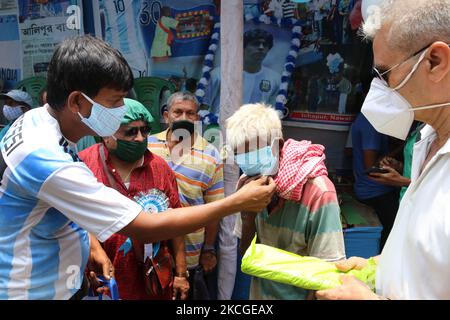 Shib Shankar Patra ( L ) , Fußballfan von Argentinien-Team, Dristribute Maske während 34. Geburtstagsfeier des weltberühmten Profi-Fußballer Lionel Messi bei North 24 Pargana Kalkutta bis 27 Kilometer Entfernungen nördlich, West Bengalen, Indien, am 24. Juni 2021. (Foto von Debajyoti Chakraborty/NurPhoto) Stockfoto