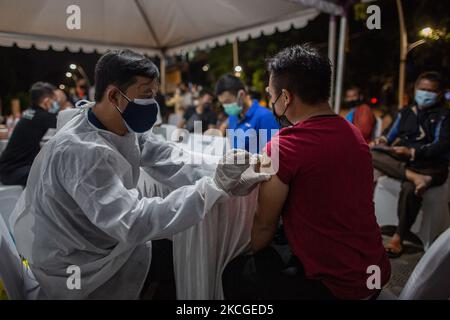 Ein indonesischer Arzt spritzt einem Mann während einer COVID-19-Impfkampagne auf dem öffentlichen Raum in Jakarta am Donnerstagabend, dem 24. Juni 2021, eine Dosis Sinovac COVID-19-Impfstoff. Indonesien hat die Impfmaßnahmen und die Maßnahmen zur sozialen Distanzierung verstärkt, da die Weltgesundheitsorganisation (WHO) vor der zunehmenden Zahl von COVID-19-Infektionsfällen im Land gewarnt hat. Am Donnerstag, dem 24. Juni, meldete Indonesien in den letzten 24 Stunden 20.574 neue Covid-19-Fälle, was der weltweit höchste Tagesanstieg war. Die Zahl sprang von bisher rund 13.000-14.000 pro Tag. (Foto von Afriadi Hikma Stockfoto