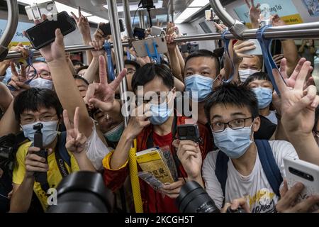 Passagiere, die im ersten Zug der Tuen Ma Line in Hongkong fahren, Sonntag, 26. Juni 2021. Heute hat die MTR-Ernte die Tune Ma-Linie vorgestellt, indem die bestehende West Rail- und die Ma-on-Shan-Linie bei Hung Hom über zwei neue Stationen nach Kwa Wan und Sung Wong Toi zusammengeführt werden. Die Tuen Ma-Linie verbindet die Ost- und West-New Territories. Mit einer Länge von 56 Kilometern und 27 Stationen ist sie heute die längste Strecke Hongkongs. (Foto von Vernon Yuen/NurPhoto) Stockfoto