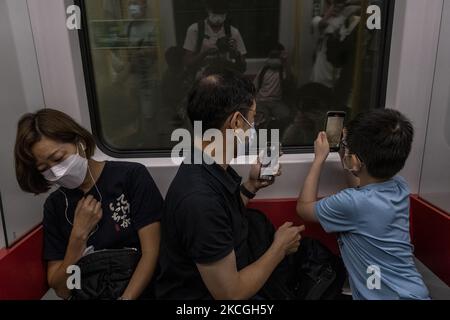 Am Sonntag, den 26. Juni 2021, fotografieren die Passagiere während der Fahrt mit dem ersten Zug der Tuen Ma Line in Hongkong. Heute hat die MTR-Ernte die Tune Ma-Linie vorgestellt, indem die bestehende West Rail- und die Ma-on-Shan-Linie bei Hung Hom über zwei neue Stationen nach Kwa Wan und Sung Wong Toi zusammengeführt werden. Die Tuen Ma-Linie verbindet die Ost- und West-New Territories. Mit einer Länge von 56 Kilometern und 27 Stationen ist sie heute die längste Strecke Hongkongs. (Foto von Vernon Yuen/NurPhoto) Stockfoto